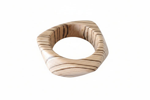 Wooden ring with a stone center on a marble surface