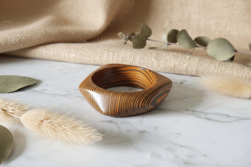 Wooden ring with a striped pattern on a marble surface