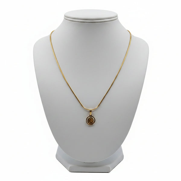 Gold necklace with a spiral pendant on a marble surface
