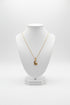 Gold necklace with a unique pendant on a marble surface