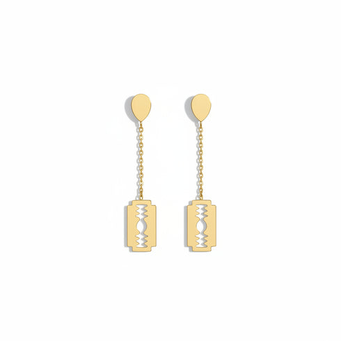 Gold earrings on a marble surface