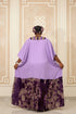 A person shown from the back wearing a loose lavender-purple kaftan-style dress with a patterned purple and black skirt, standing indoors in front of dark horizontal blinds. Large overlaid text reads, 'Which color is your fav? Price - N50,000 each WhatsApp 2347035008482'.