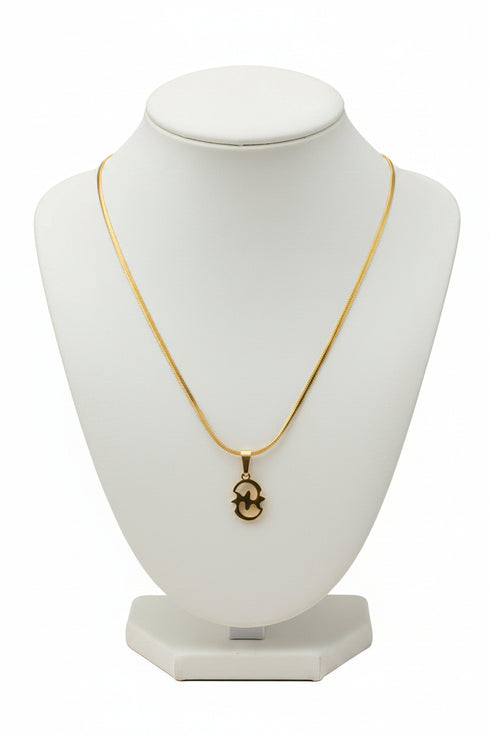 Gold necklace with a decorative clasp on a marble surface
