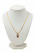 Gold necklace with a decorative clasp on a marble surface