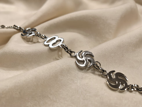 Silver bracelet with decorative links on a beige fabric background