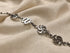 Silver bracelet with decorative links on a beige fabric background