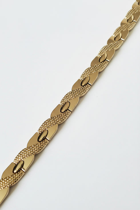 Gold chain bracelet on a marble surface