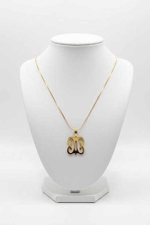 Gold necklace with a decorative clasp on a marble surface