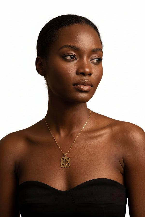 Gold necklace with an ornate clasp on a marble surface
