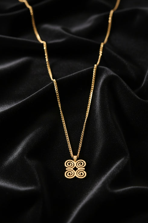 Gold chain necklace with decorative clasp on a marble surface