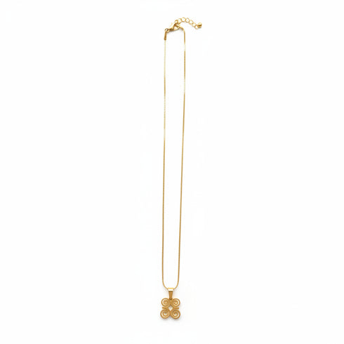 Gold necklace with floral ends on a marble surface