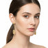 Gold earrings on a marble surface