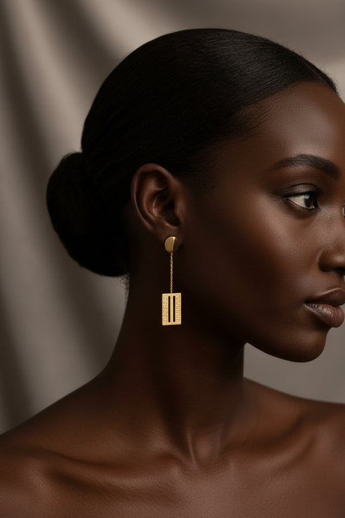 Gold earrings on a marble surface