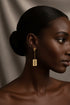 Gold earrings on a marble surface
