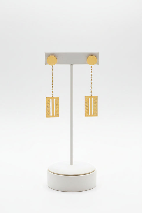 Gold earrings on a marble surface