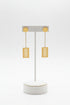 Gold earrings on a marble surface