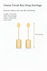 Gold earrings on a marble surface