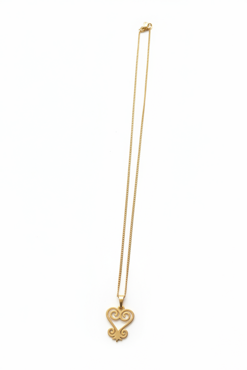 Gold necklace with a heart-shaped pendant on a white background
