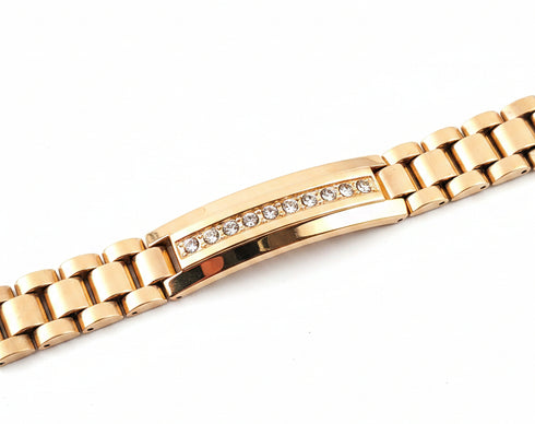 Gold watch strap with diamond accents on a marble surface