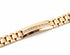 Gold watch strap with diamond accents on a marble surface