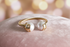Gold ring with two pearls on a pink velvet surface