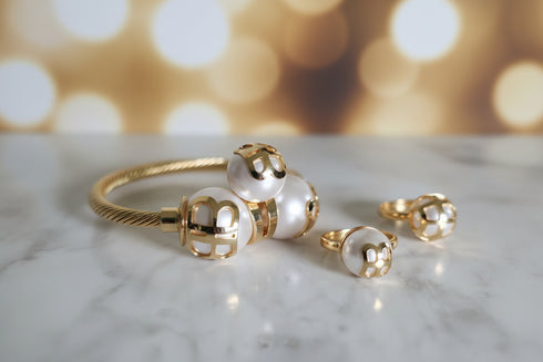 Gold and pearl ring on a marble surface