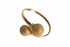 Gold bangle with textured spherical ends on a marble surface