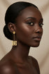 Pair of gold earrings on a marble surface