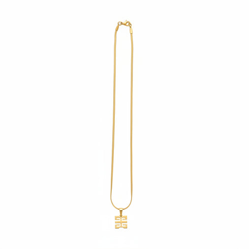 Gold necklace with a unique clasp on a marble surface