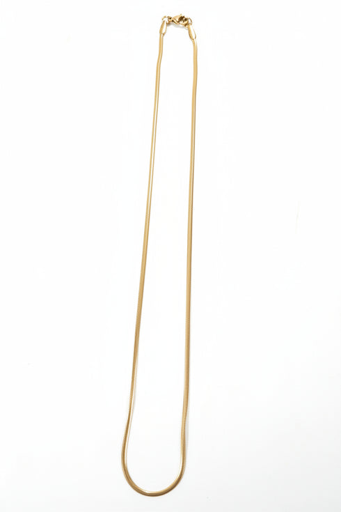 Gold necklace on a marble surface