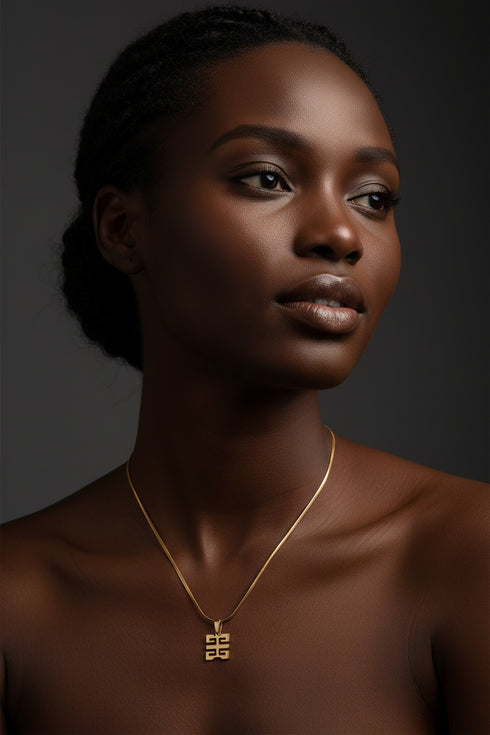 Gold necklace with a unique clasp on a marble surface