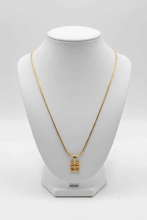 Gold necklace with a decorative clasp on a marble surface