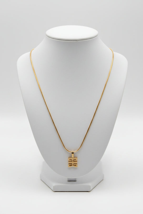 Gold necklace with a decorative clasp on a marble surface