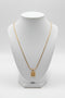 Gold necklace with a decorative clasp on a marble surface