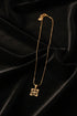Gold necklace with a unique clasp on a marble surface