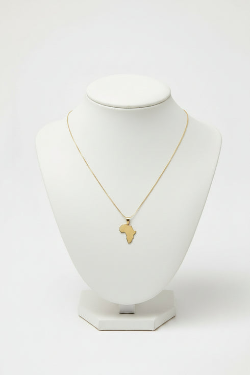 Gold necklace with a African map pendant on a marble surface