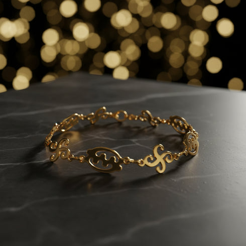 Gold bracelet with intricate designs on a white background