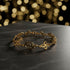 Gold bracelet with intricate designs on a white background