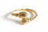 Gold bracelet with textured design on a white background