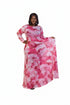 A woman modeling a long-sleeved maxi dress with a pink and white abstract watercolor pattern, standing against a plain white studio background.