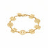 Gold bracelet with monogrammed charms on a marble surface