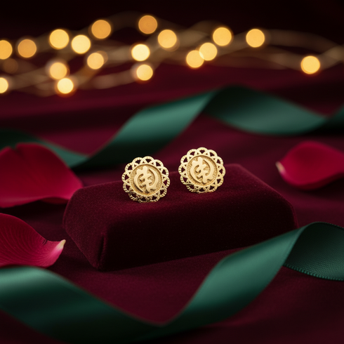 Gold earrings on a red cushion with blurred lights and ribbons in the background