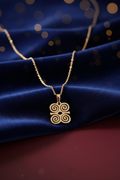 Gold necklace with a decorative clasp on a marble surface