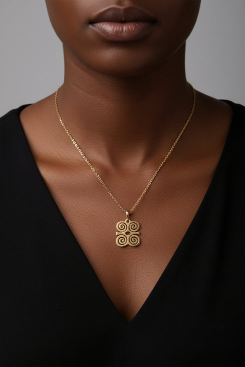 Gold necklace with a decorative clasp on a marble surface