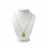 Gold necklace with a pendant on a white mannequin bust against a white background