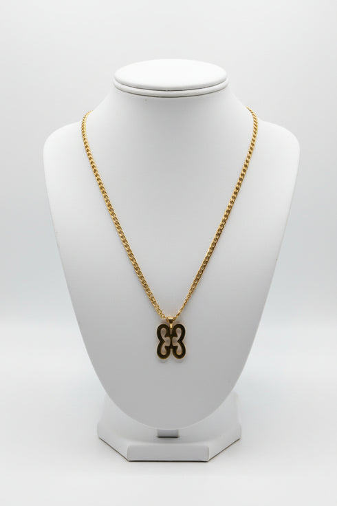 Gold chain with a decorative clasp on a marble surface