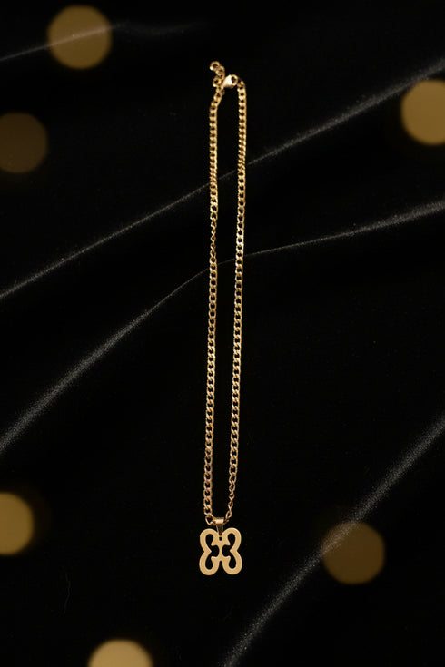 Gold chain with a decorative clasp on a marble surface