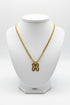 Gold chain necklace with a butterfly pendant on a marble surface