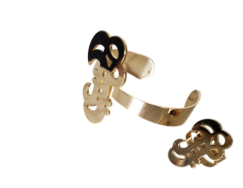 Gold bracelet with decorative elements on a marble surface