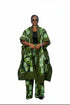 A woman modeling a matching green and white patterned two-piece outfit consisting of a long open-front kaftan-style jacket and wide-leg pants, worn over a black top against a plain white background.